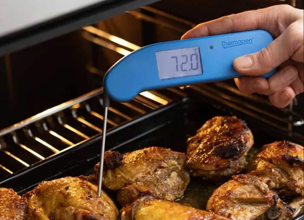 A blue coloured Thermapen ONE checking the temperature of meat in the oven