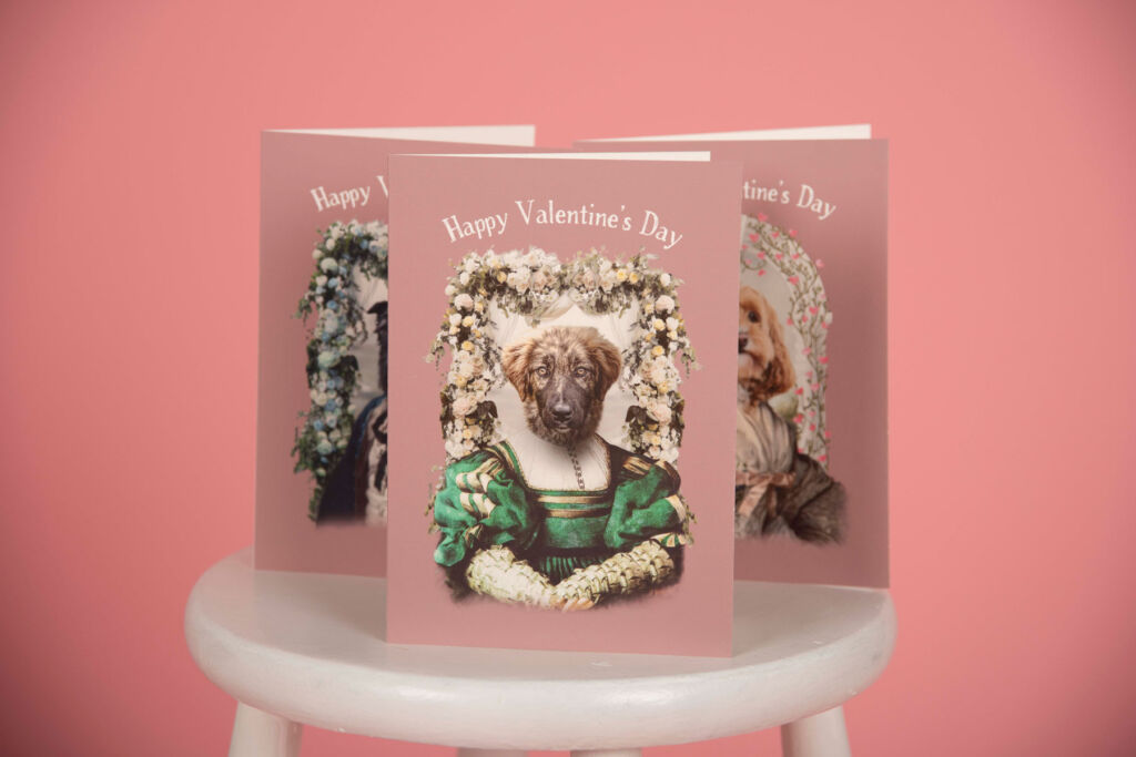 Three cards with dogs on the front positioned on a white stool