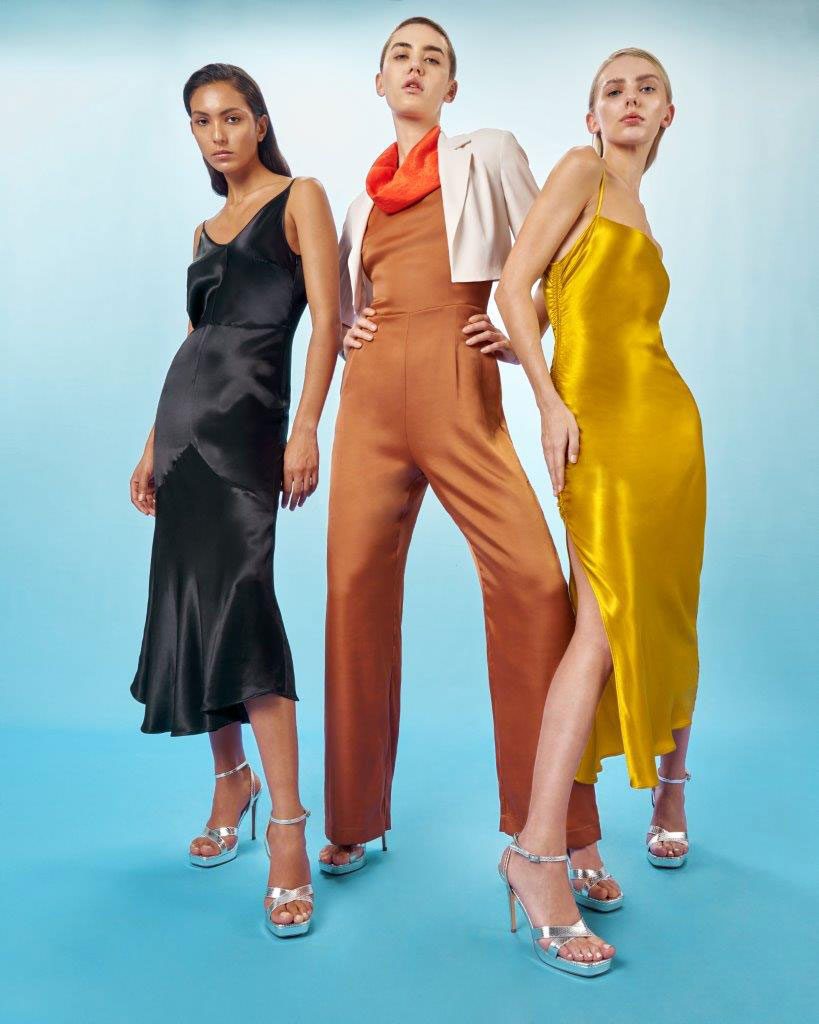 Three female fashion models in brightly coloured clothing