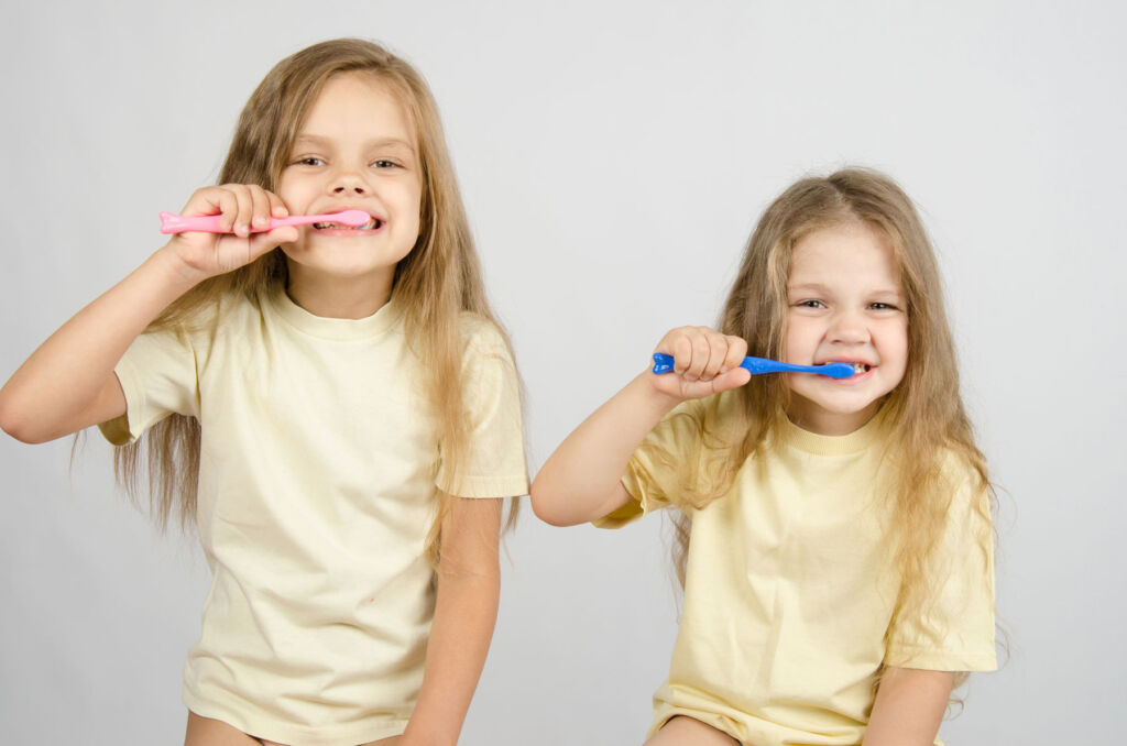 Two young girls brushing their teeth