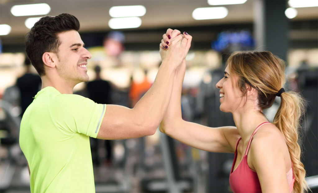 A man and a woman congratulating each other after getting fitter