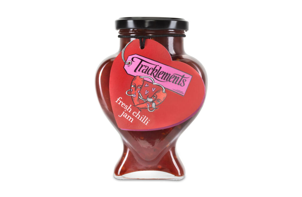 A jar of the heart-shaped chilli jam on a white background