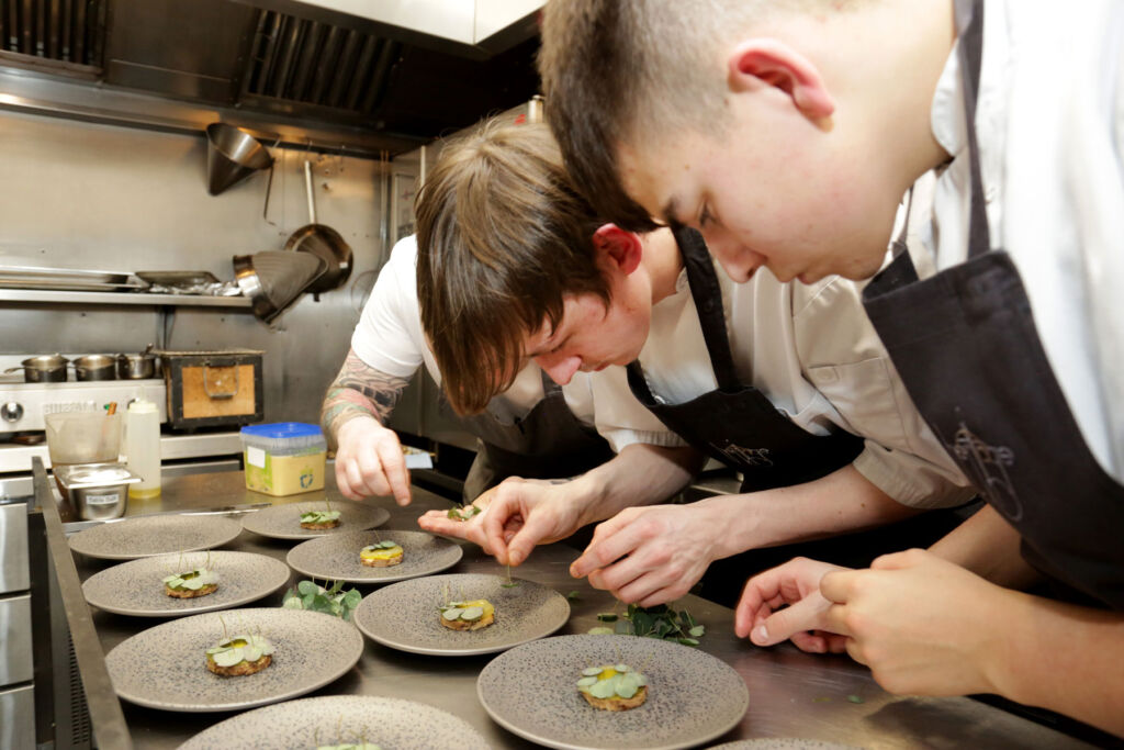 Young chefs preparing dishes in a restaurant kitchen