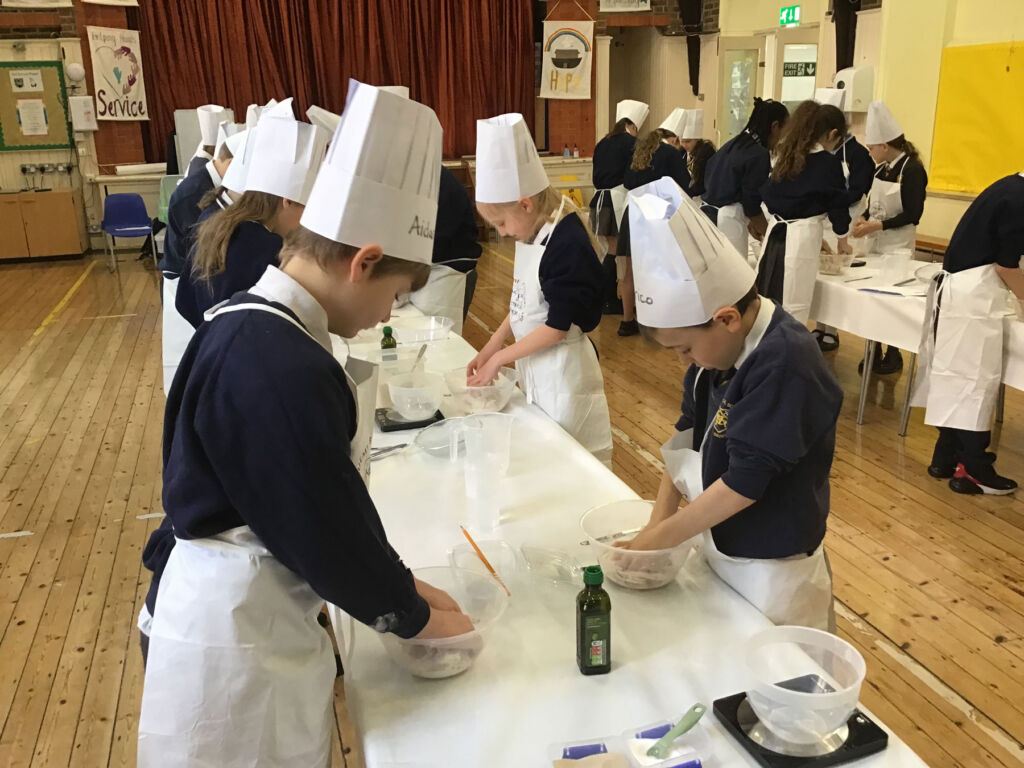 Children wearing chef hats learning to cook