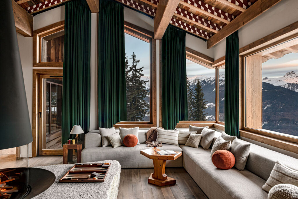The living room with its large windows offering incredible views of the snow covered mountains
