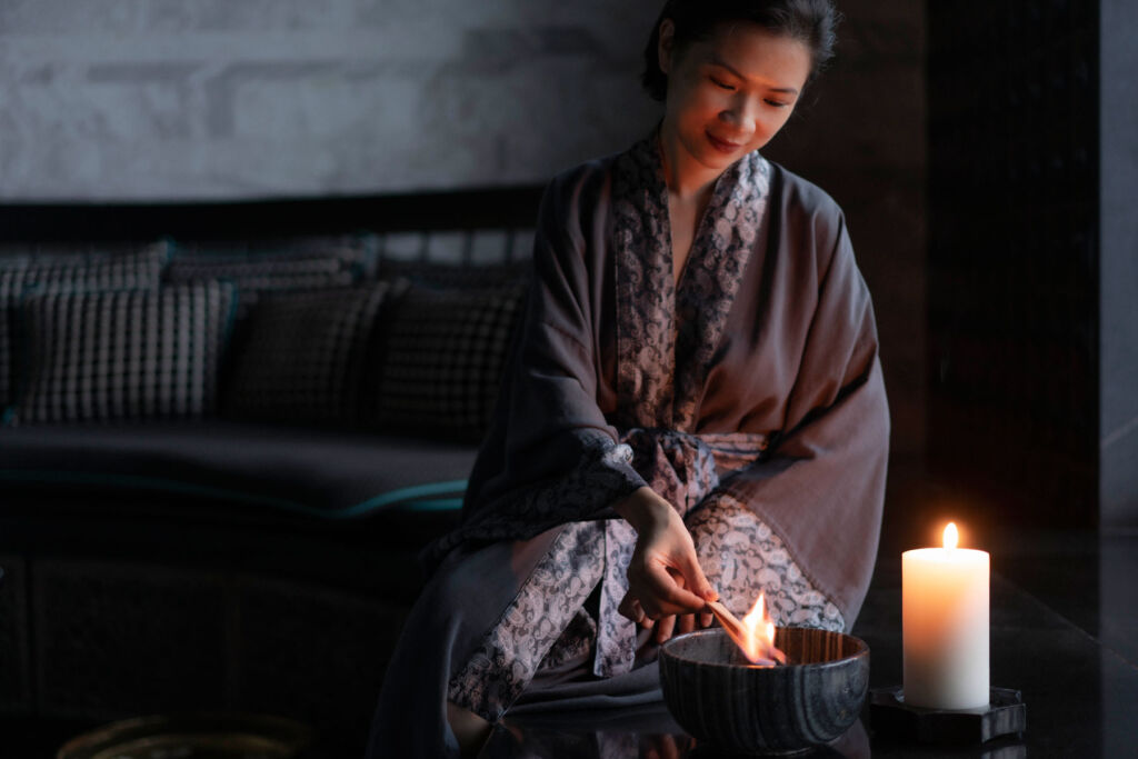 A woman lighting candles at the spa ritual