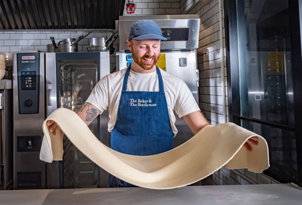 Ben holding and folding a large roll of pastry
