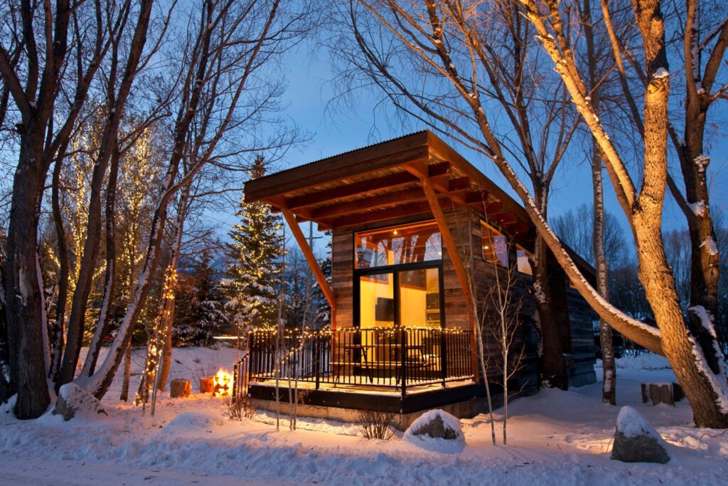 A cabin style modular home in a snowy forest