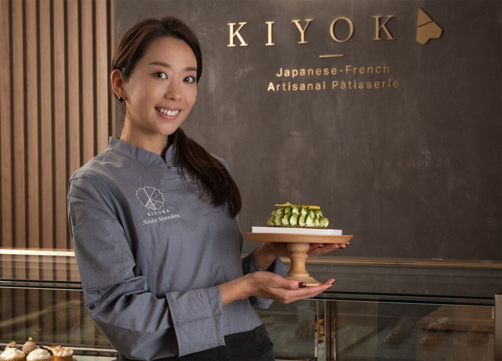 The chef proudly holding one of her finished desserts