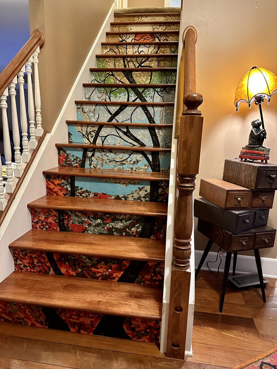 A wooden staircase which has tiles embedded in each riser