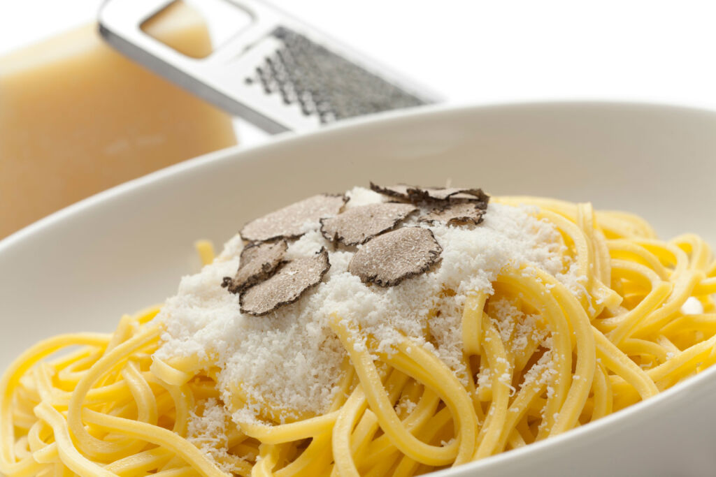 A Spaghettis dish topped with parmesan cheese and the mushroom