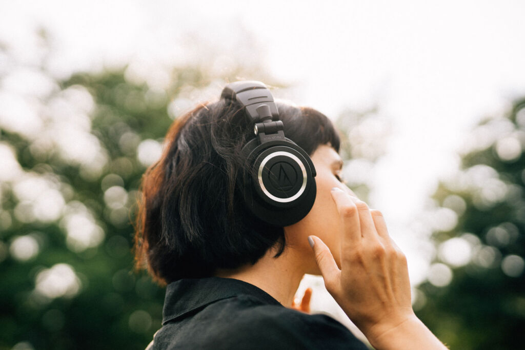 A woman wearing the headphones outdoors