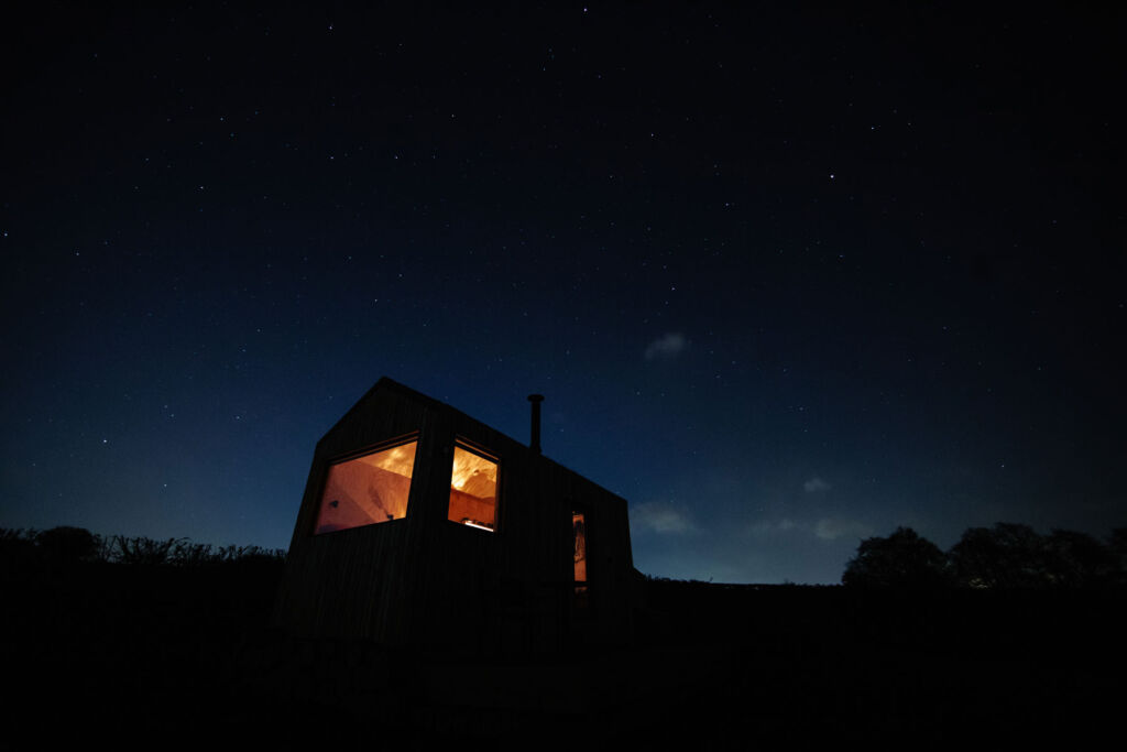 The cabin at night under a starry sky