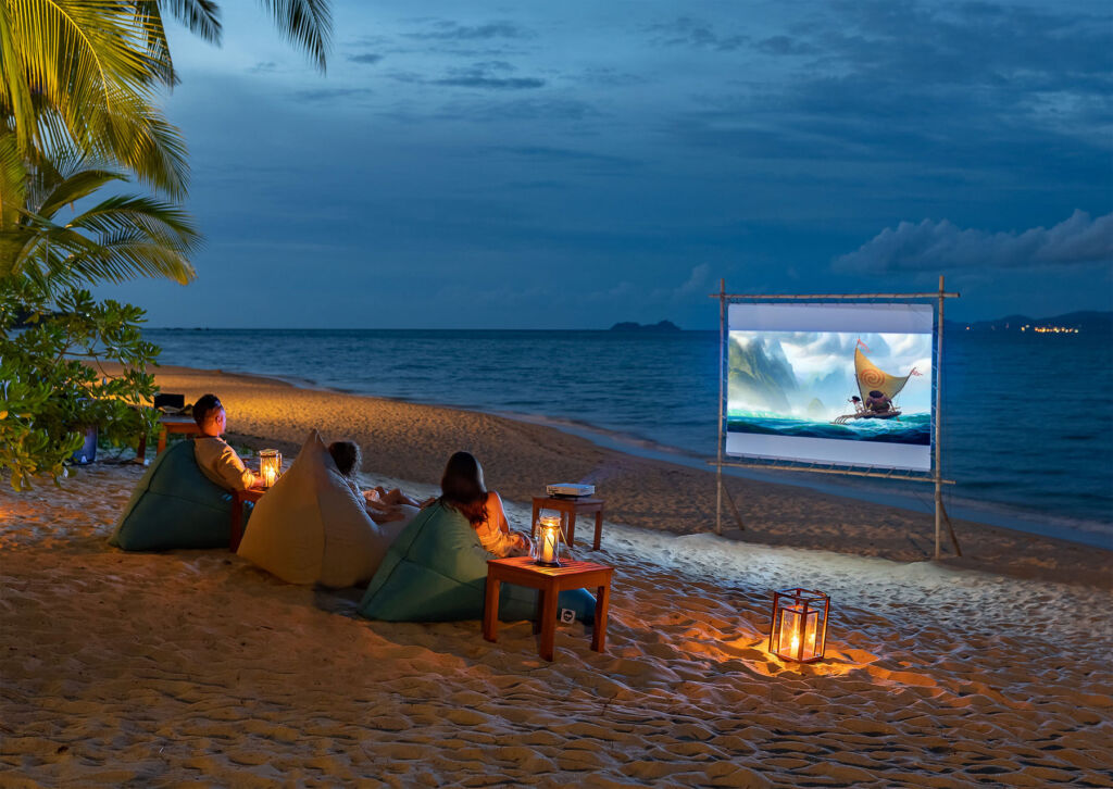 A family watching a movie on the beach