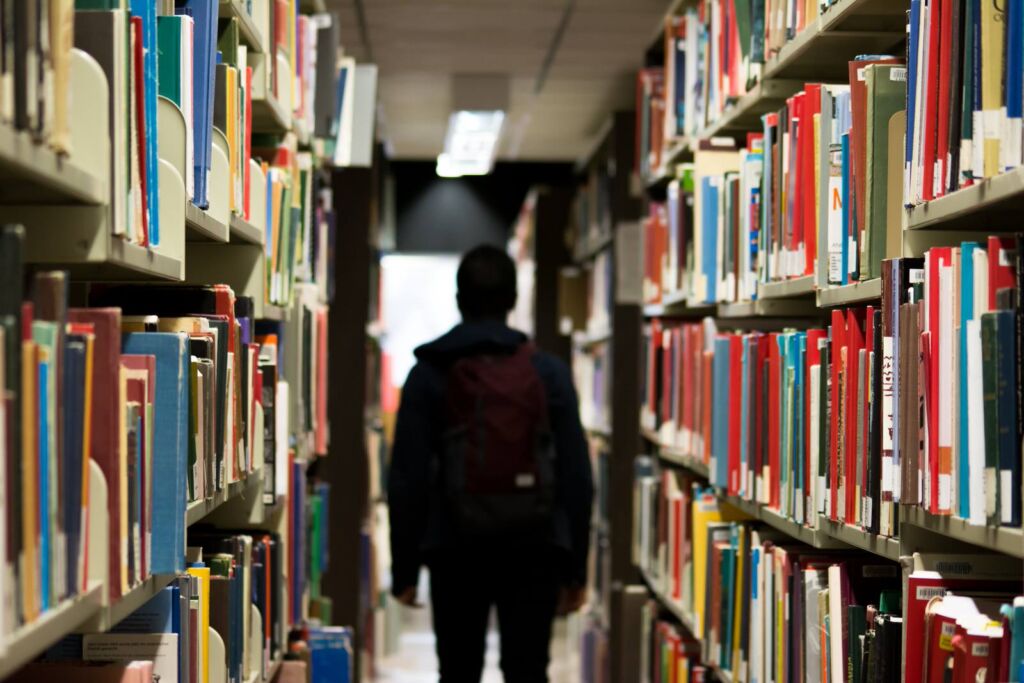 A person walking along an aisle in the library