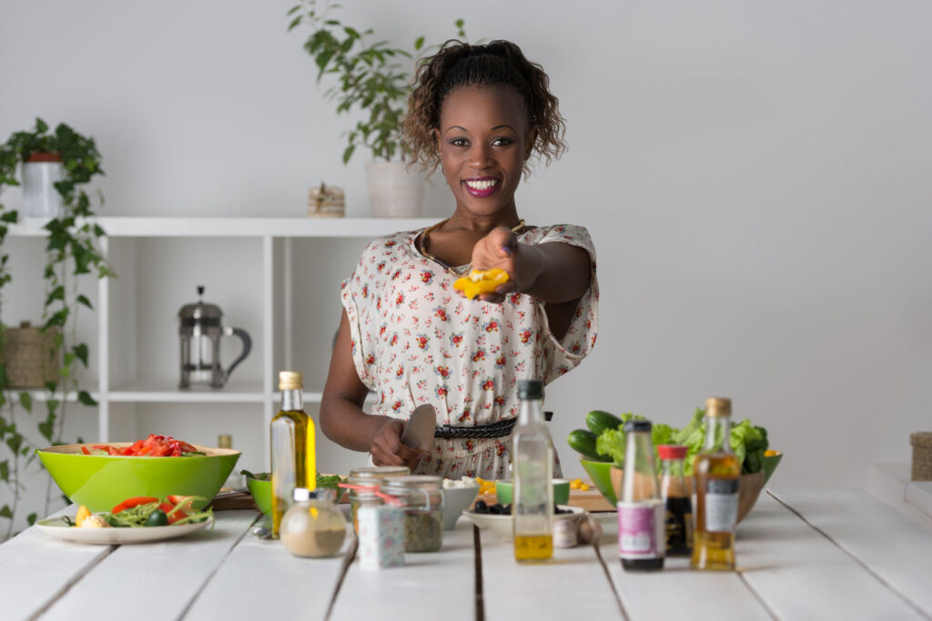 A woman with a range of healthy foods on her kitchen worktop