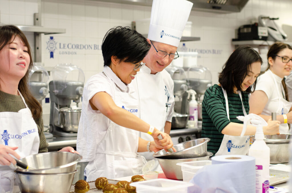 Woman taking part in one of the cooking classes, which is being led by a top chef