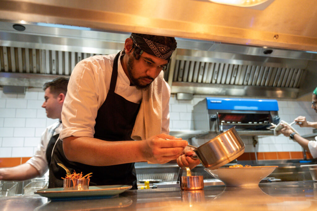 A member of staff preparing a dish in the open kitchen