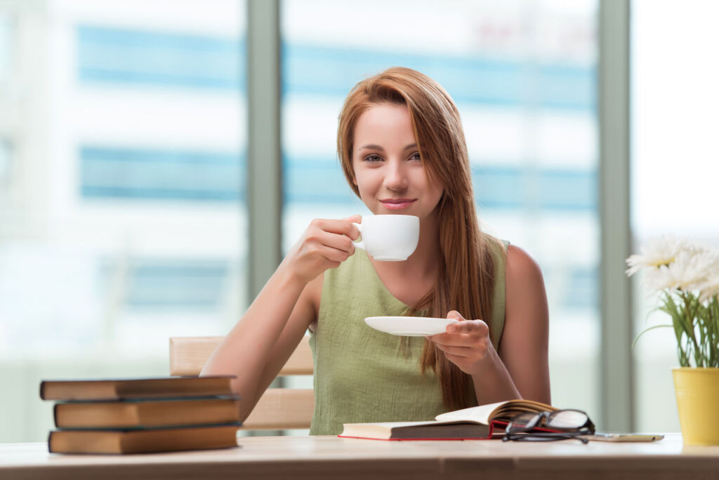 A young woman drinking a cup of tea in the office