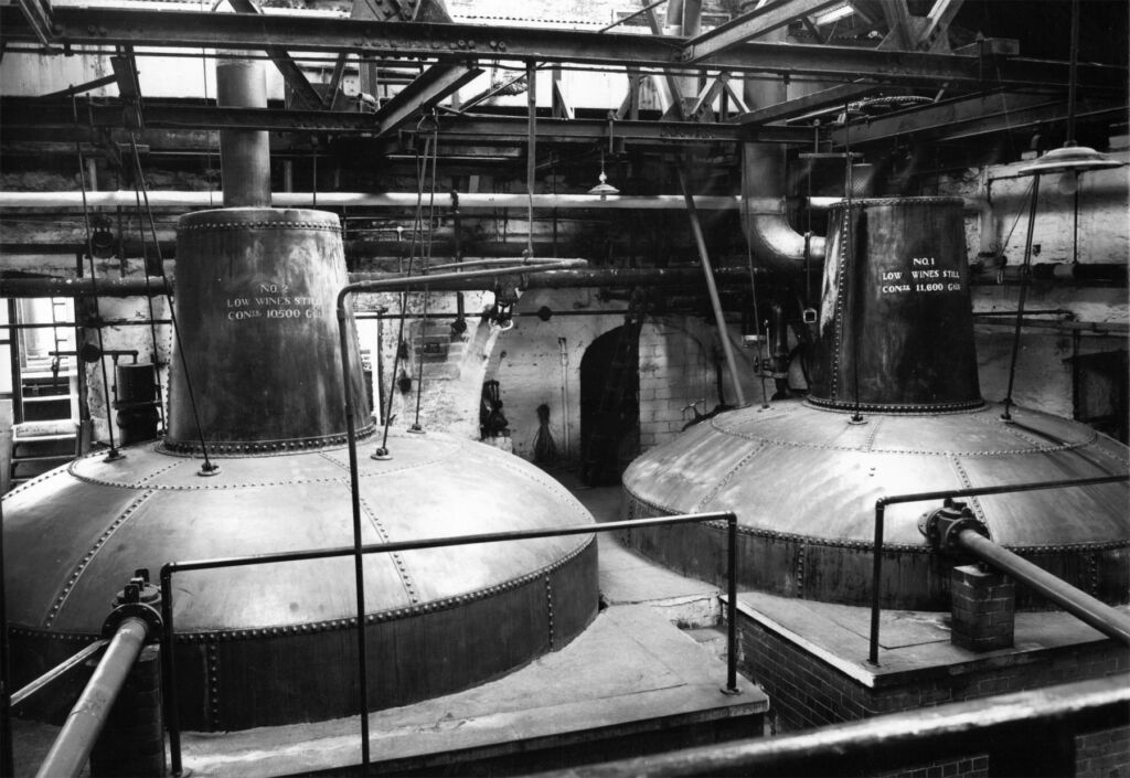 A black and white photograph of the distillery's pot stills