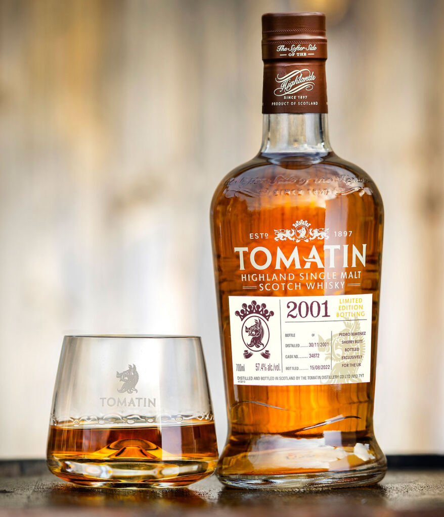 A bottle of the Tomatin Single Malt 2001 next to a half filled glass