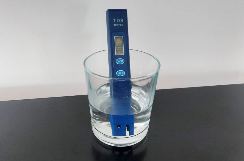 The water tester in a glass checking the quality of our tap water