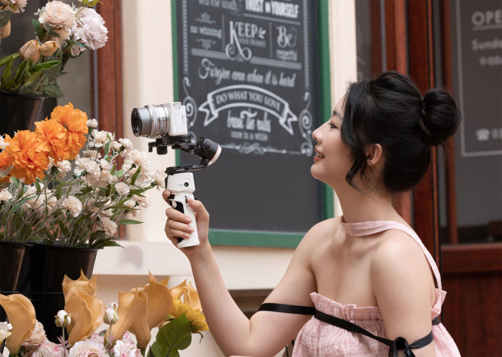 A woman filming flowers with the M 3S