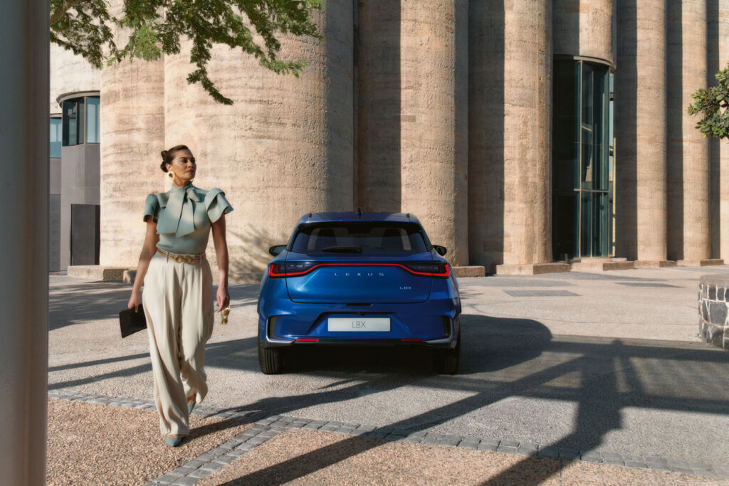 A woman walking away after parking her blue coloured Lexus