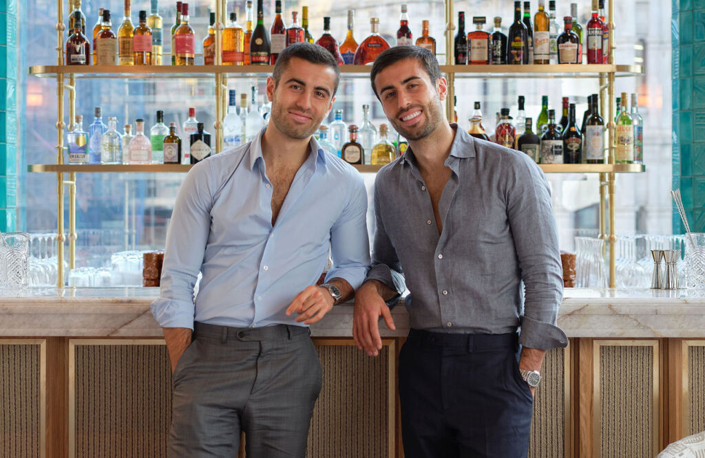 Brothers Alberto and Arian Zandi, leaning on the bar in the restaurant