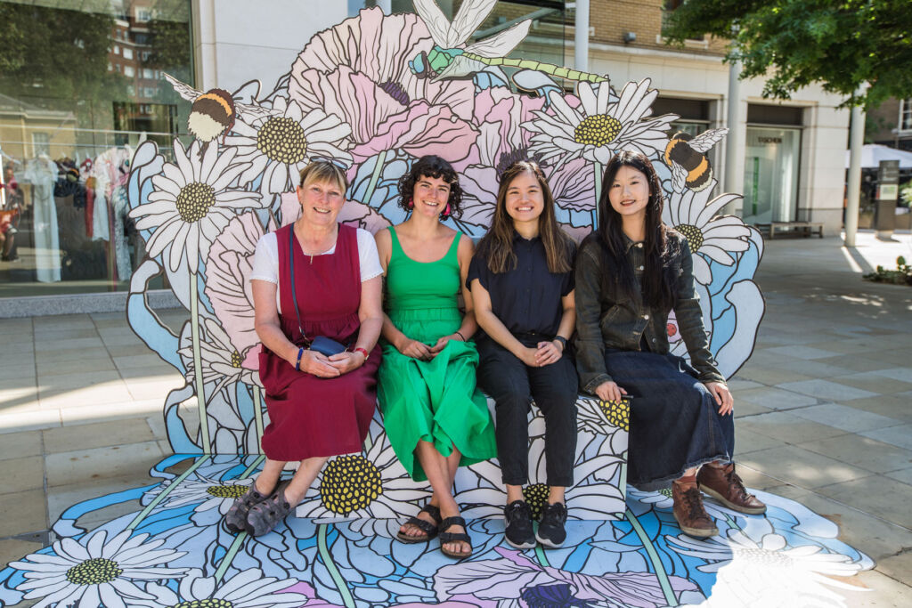 Four ladies sitting on one of the art installations