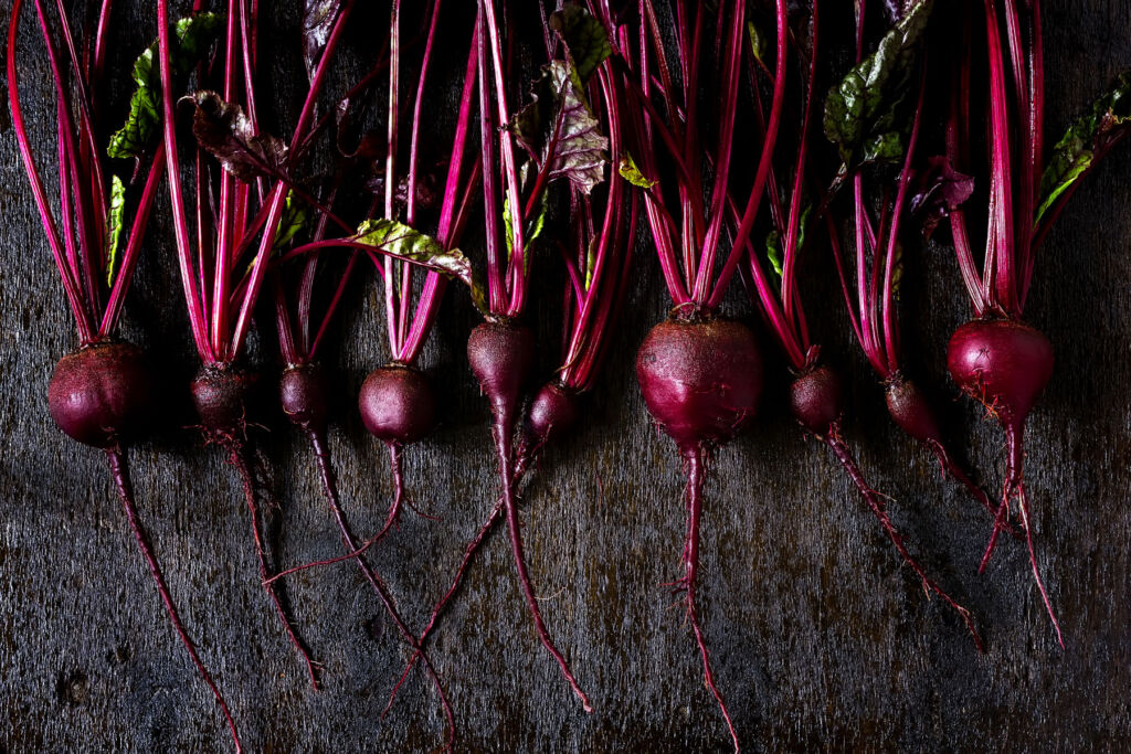 Fresh beetroots laid side by side on a table top