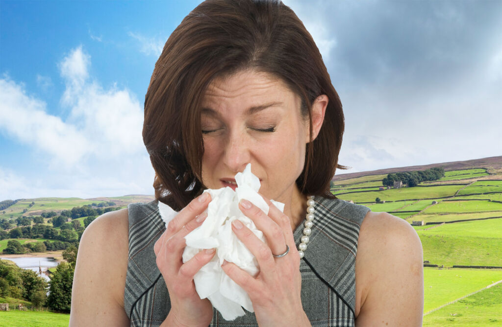 A woman blowing her nose into a handkerchief