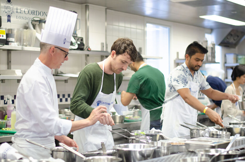 Students being taught the art of cooking by a leading chef