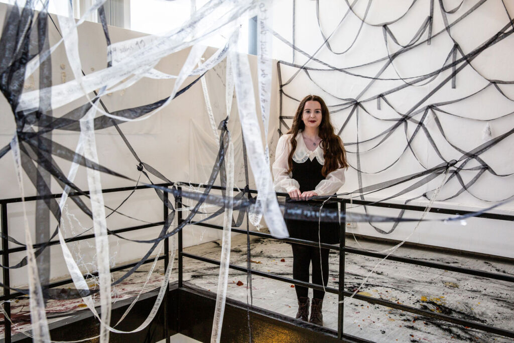 Miriam Foy standing inside a contemporary artwork