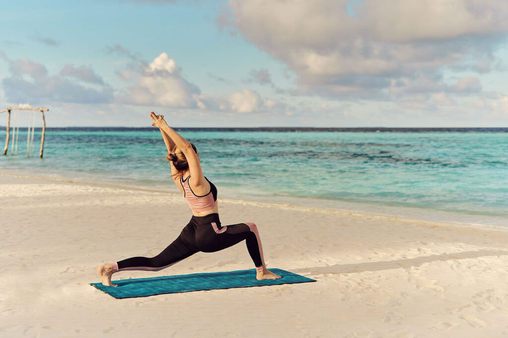 A young woman doing yoga on the beach