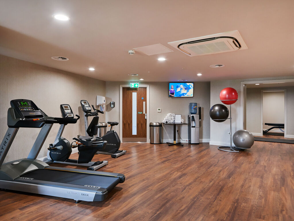 The wood-floor gym with a selection of aerobic machines and fitness balls