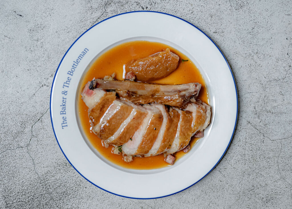 The Iberico Pork Chop dish on a white plate with blue edging