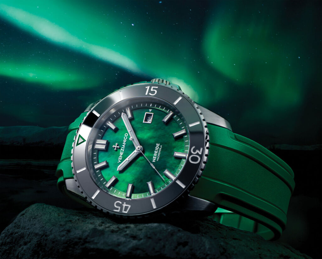 The watch laid on its side on a rock with the Aurora Borealis in the background