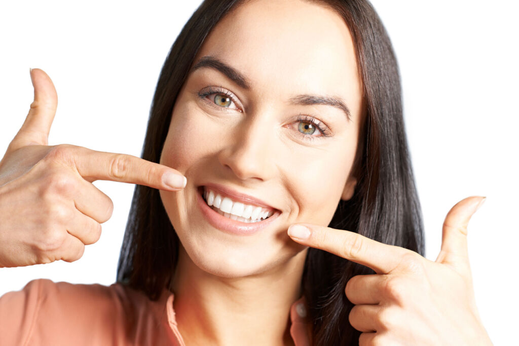 A woman pointing to her teeth