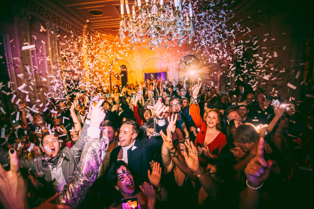 A photo of confetti falling from the ceiling on a room full of happy guests