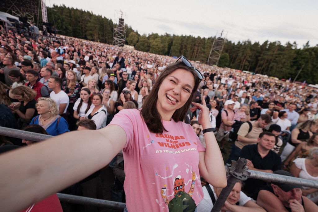 A young woman taking a selfie in front of the crowd