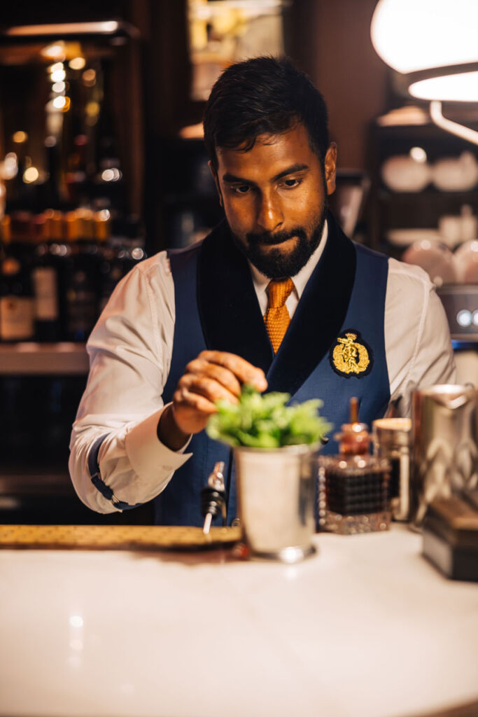 A male member of the bar team preparing a cocktail