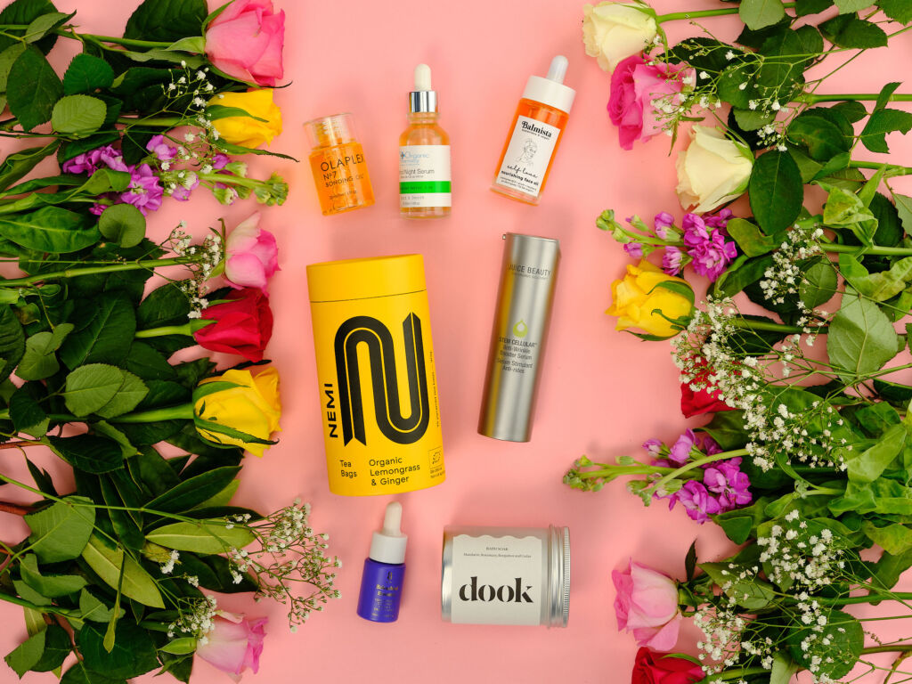 A selection of beauty products framed with fresh flowers