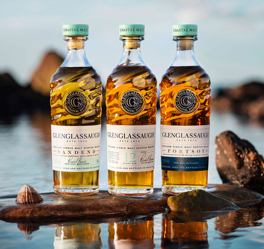 The Glenglassaugh trio of new whiskies on a rock on the sea shore