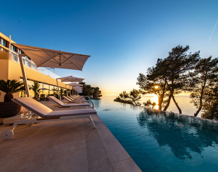 The view over the infinity pool over the sea at sunset