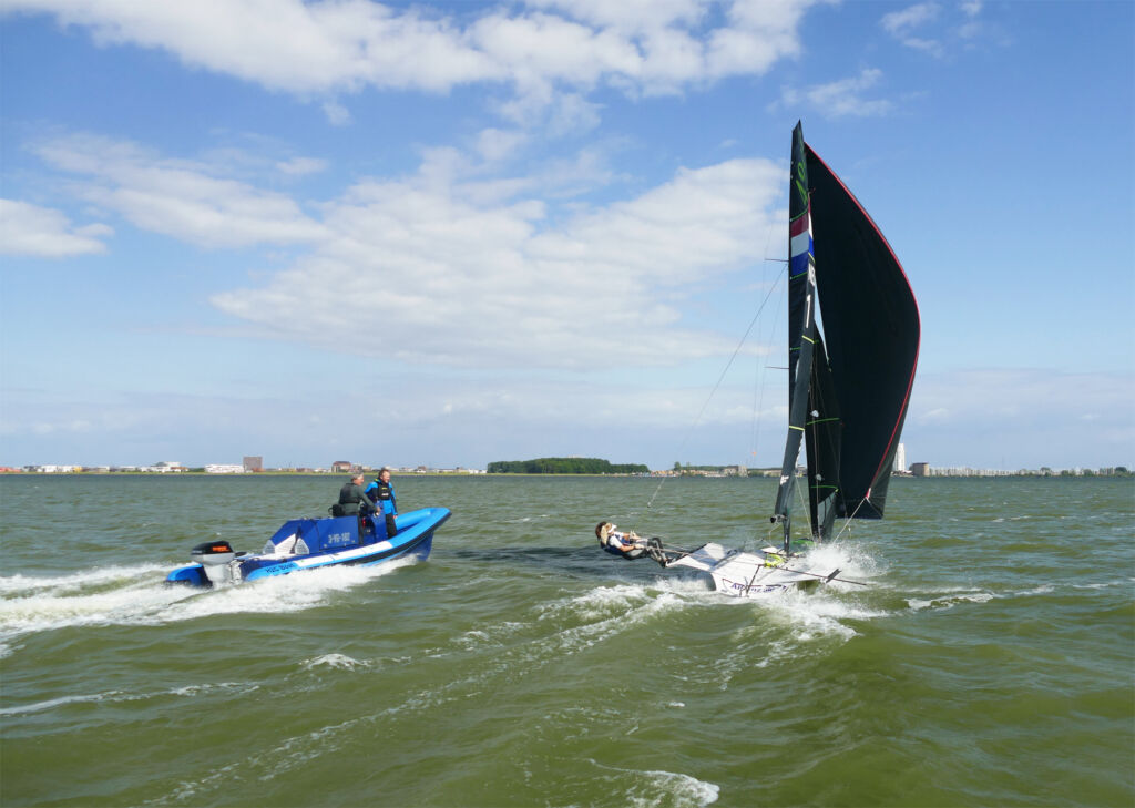 The boat running beside a competitive sailor in training