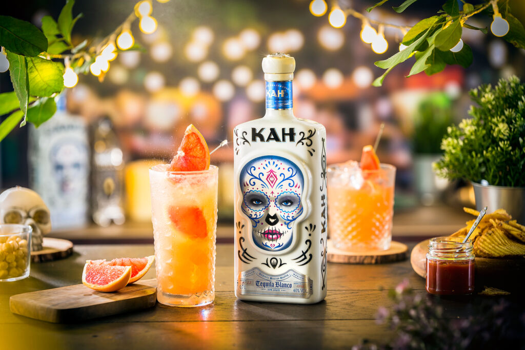 The gorgeous looking KAH bottle on a wooden table lit by fairy lights