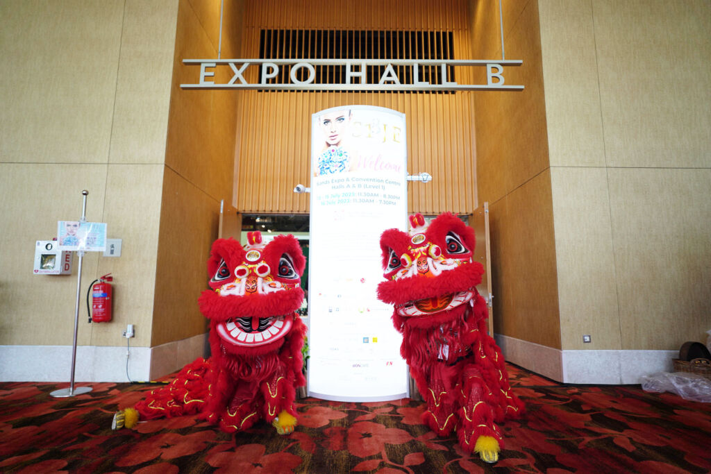 Two red lion dancers outside Expo Hall B