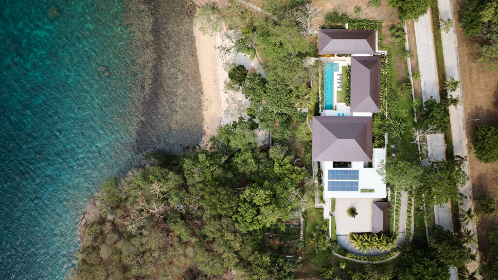 
A top down view of an ocean-front property with solar panels on its roof