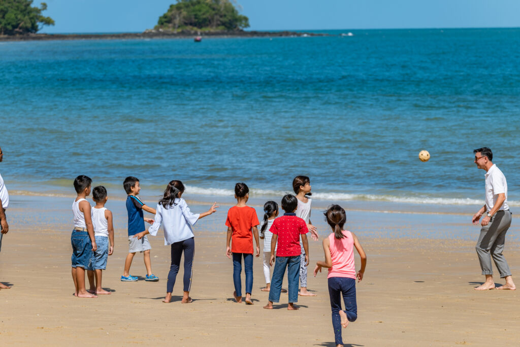 Children engaging in a fun activity on the beach with Youth for the Future leader, Johan Pillar